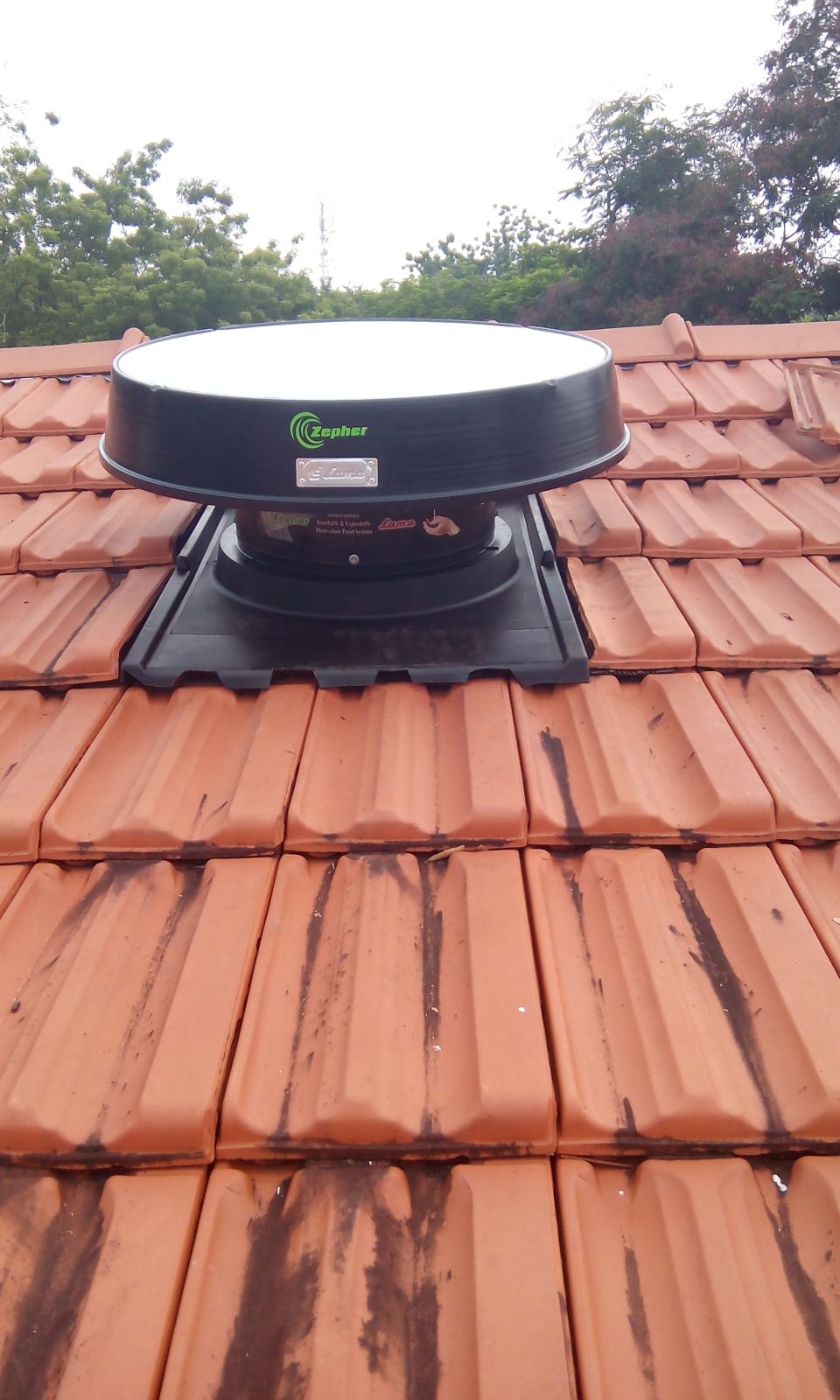 Solar roof ventilator on tile roof